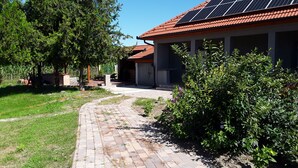 A residential property with a paved driveway, solar panels on the roof, and a well-maintained garden. - Charming house in Tápiószentmárton (Tápiószentmárton)