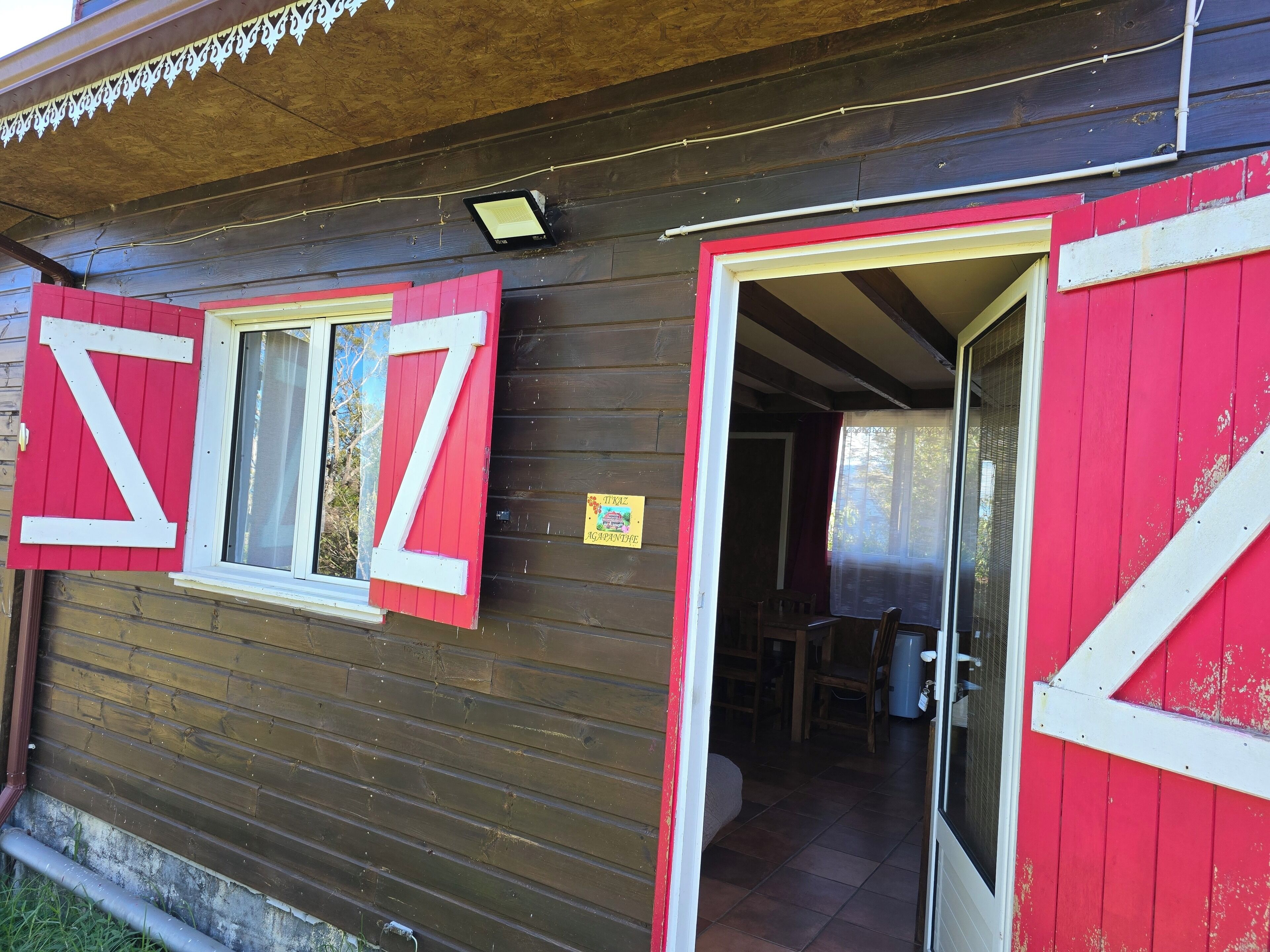 Un edificio de madera con una puerta roja y una gran letra 'Z' blanca en la pared.