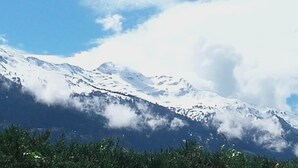 Un paysage de montagne avec des sommets enneigés et un ciel dégagé.