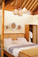 Un dormitorio con cama de madera, un armario y tres platos decorativos colgados en la pared.