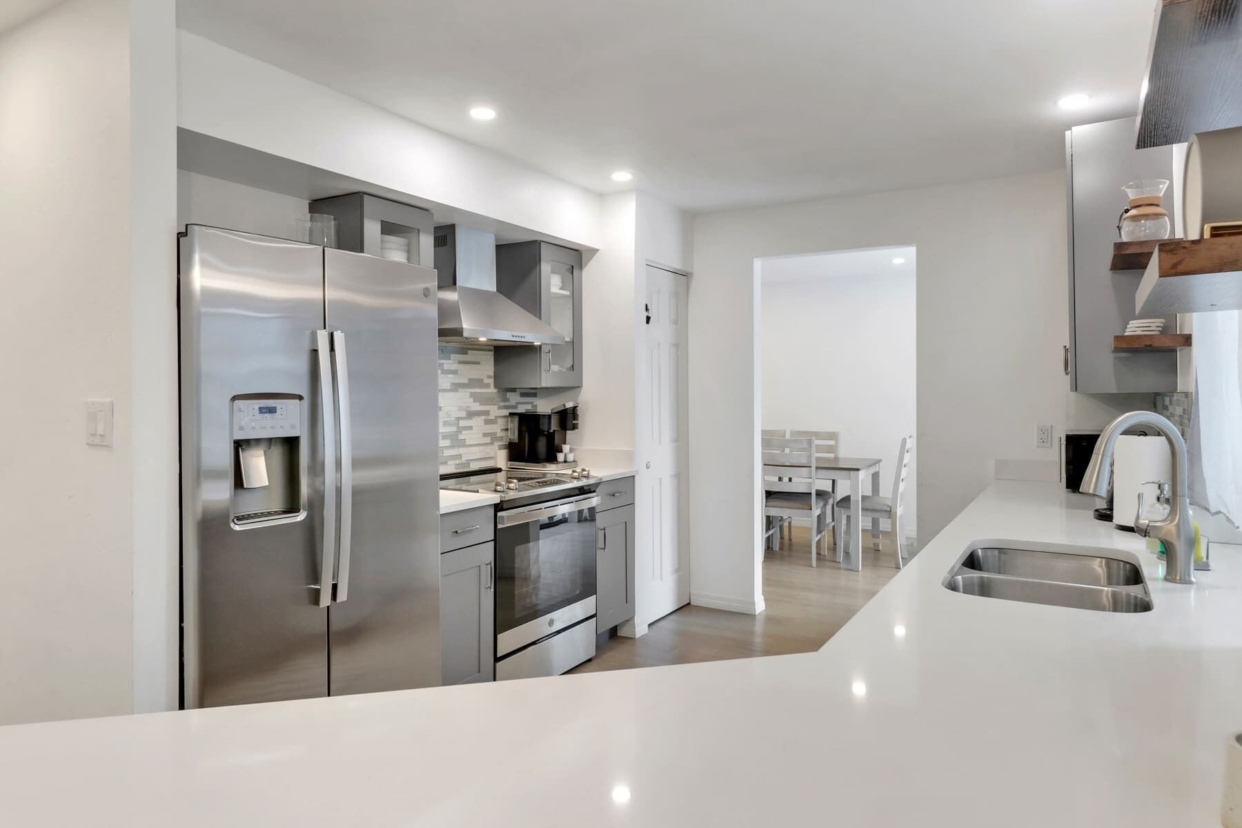 A modern kitchen with stainless steel appliances, a built-in oven, and a water dispenser.