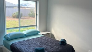 A bedroom with a bed, a window, and a ceiling light. - Secure 4BR w/Garage Whyalla (Whyalla Jenkins)