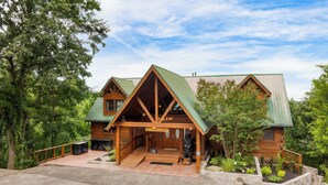 A log cabin-style building with a green roof, a porch, and a sign reading "Big Bear Lodge". - Sleeps 22, 2 Homes | Theater Room, Game Room, Hot Tub, Smoky Mountain Views (Sevierville)