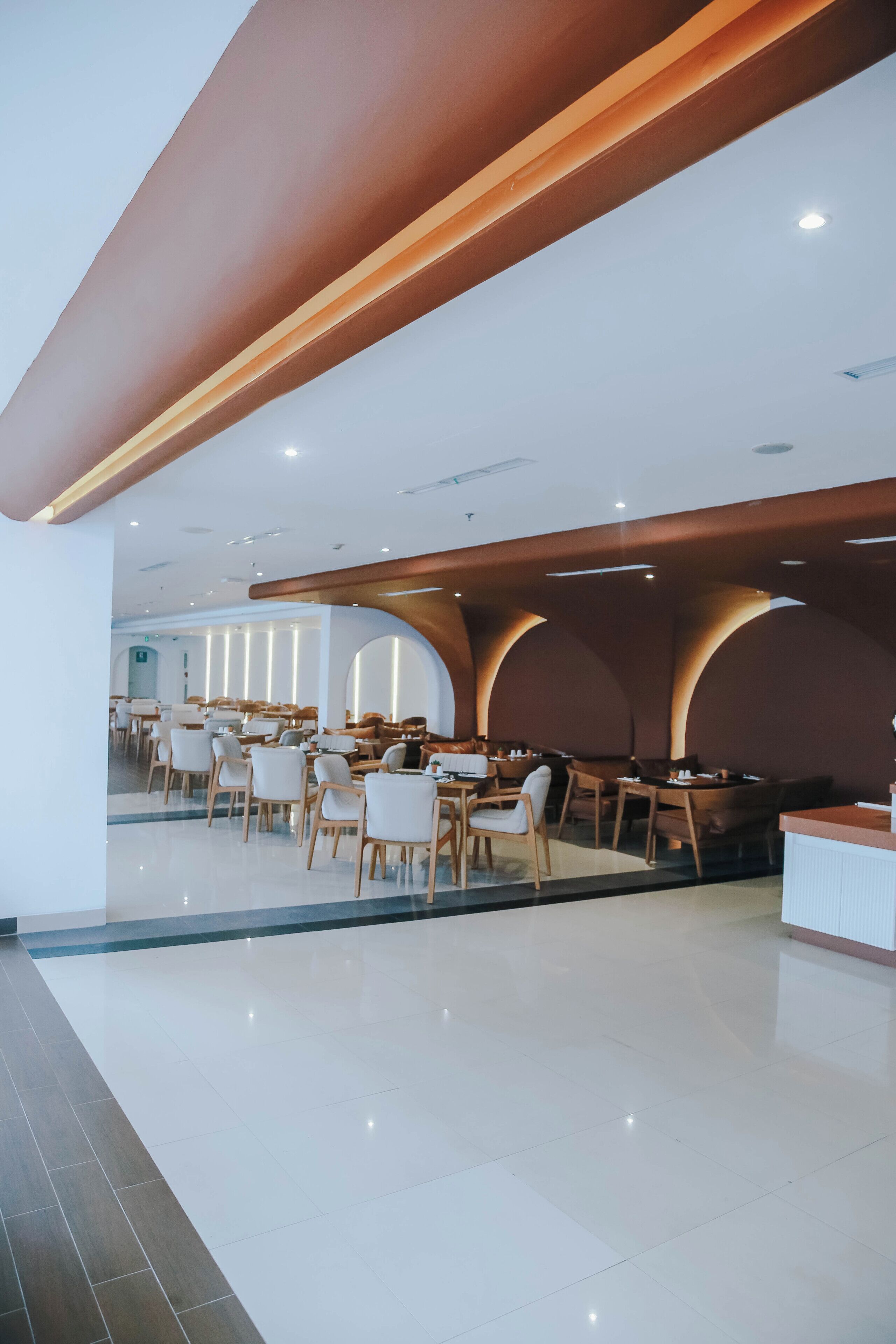 A spacious restaurant with high ceilings, wooden beams, and a modern interior design.