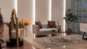 A modern living room with a sofa, coffee table, and decorative items. - Omar Hotel (Tangerang)