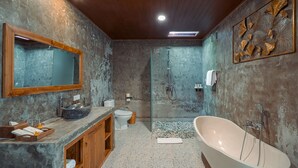 A modern bathroom with a freestanding bathtub, a glass-enclosed shower, and a marble vanity. - Matahari Lumbung Resort (Ubud)