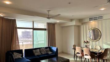 A spacious living room with a sofa set, a coffee table, and a dining area with chairs and a table.