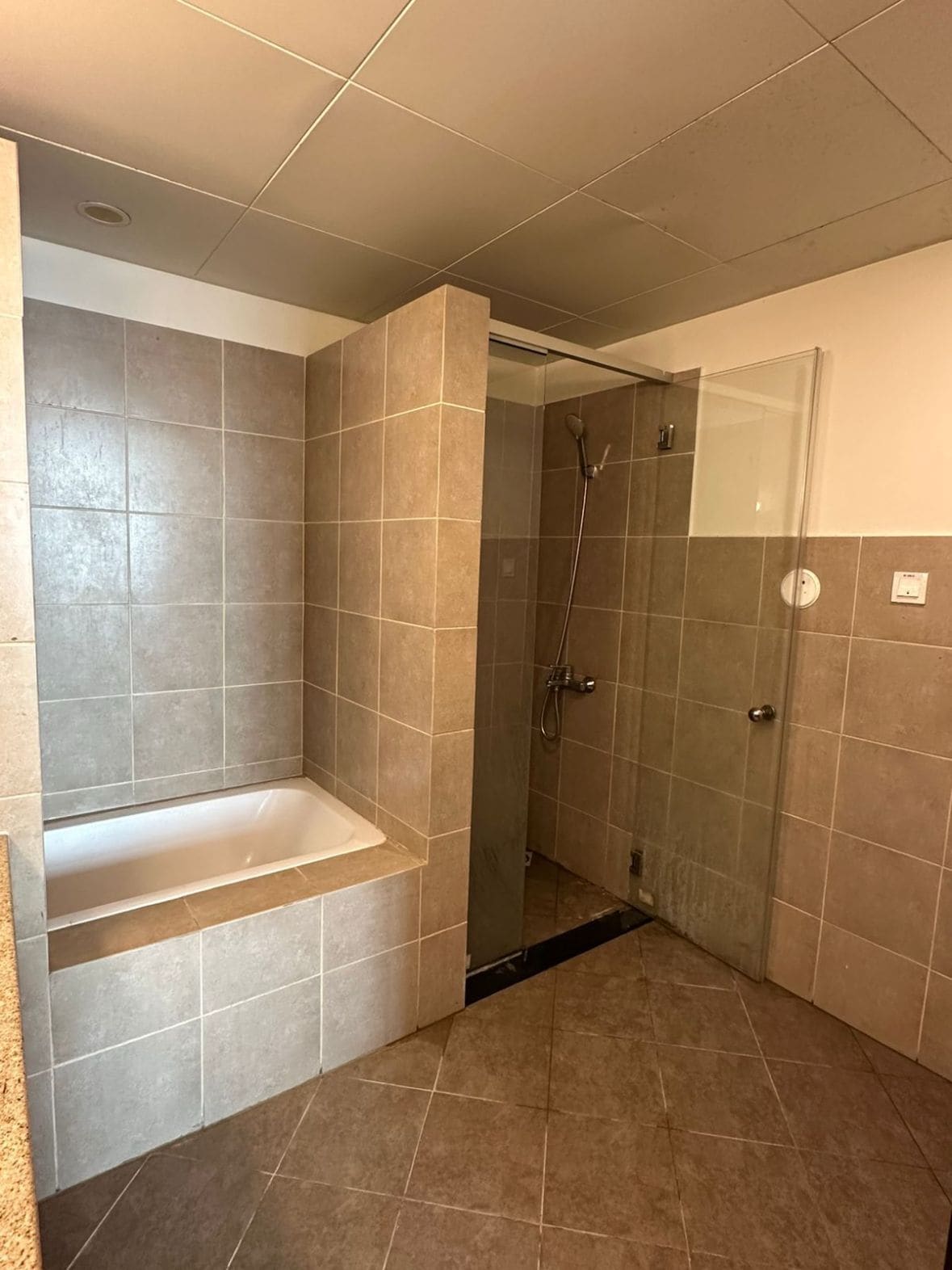 Ein Badezimmer mit Badewanne, Dusche und gefliesten Wänden.