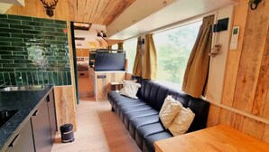 A compact, modern interior with a kitchenette, a sofa, and a dining table. - Luxury tiny house with sauna in Lierneux (Lierneux)
