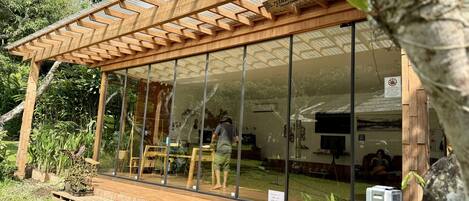 A wooden structure with large glass windows, a wooden deck, and a sign indicating a smoking area.