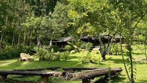 A natural setting with wooden structures and picnic tables.