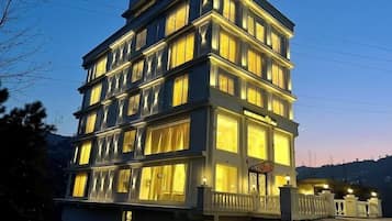 Vista frontal de la propiedad por la tarde o noche