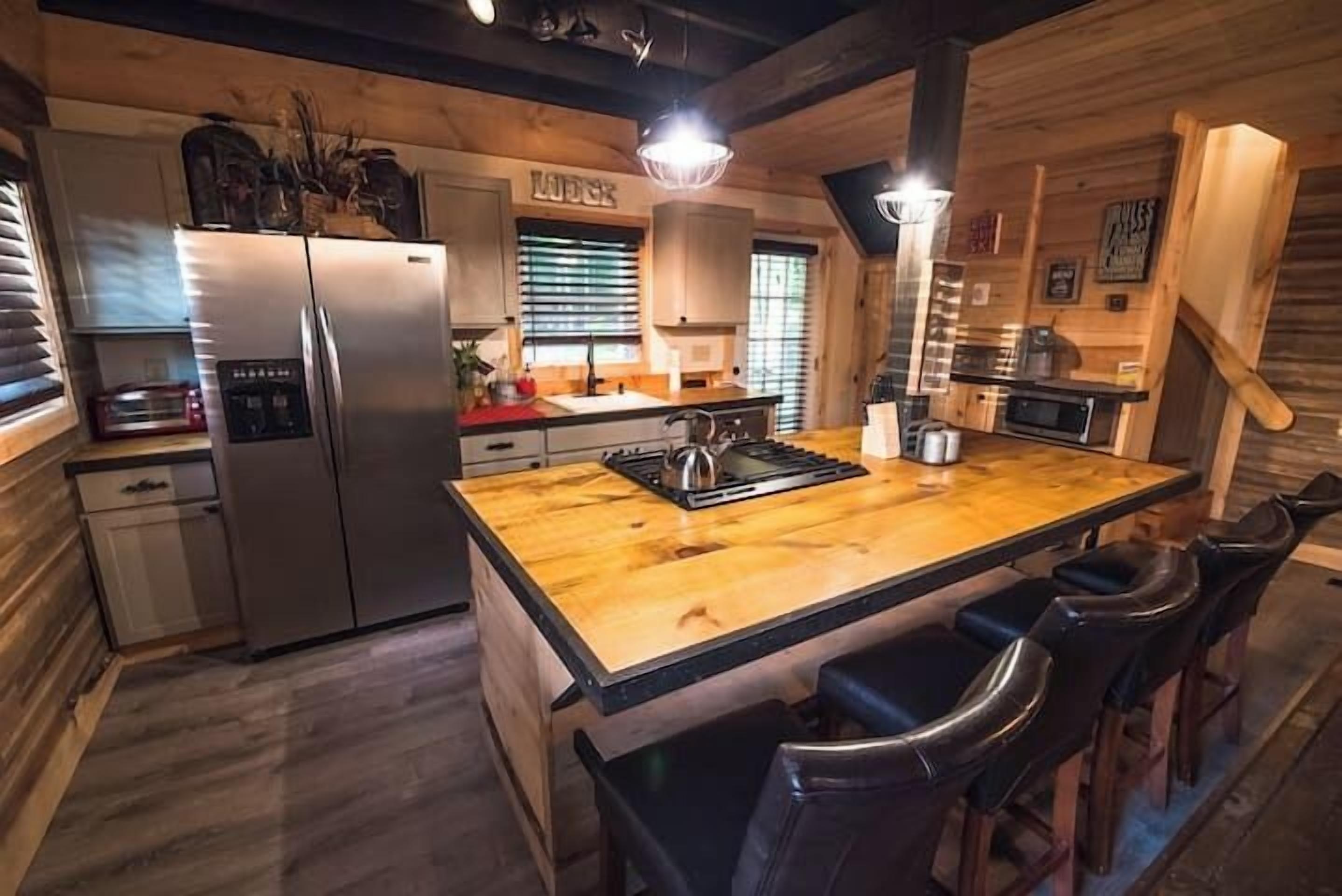 A compact kitchen with a central island, a refrigerator, and a microwave.
