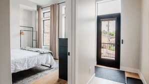A bedroom with a bed, a wardrobe, and a window with curtains.