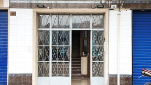 A building entrance with a tiled facade, a blue shutter door, and a metal gate. - Gresy Boutique Apartment (Naples)