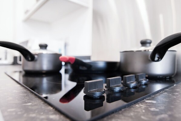 A kitchen stove with four burners and a pot on the left burner.
