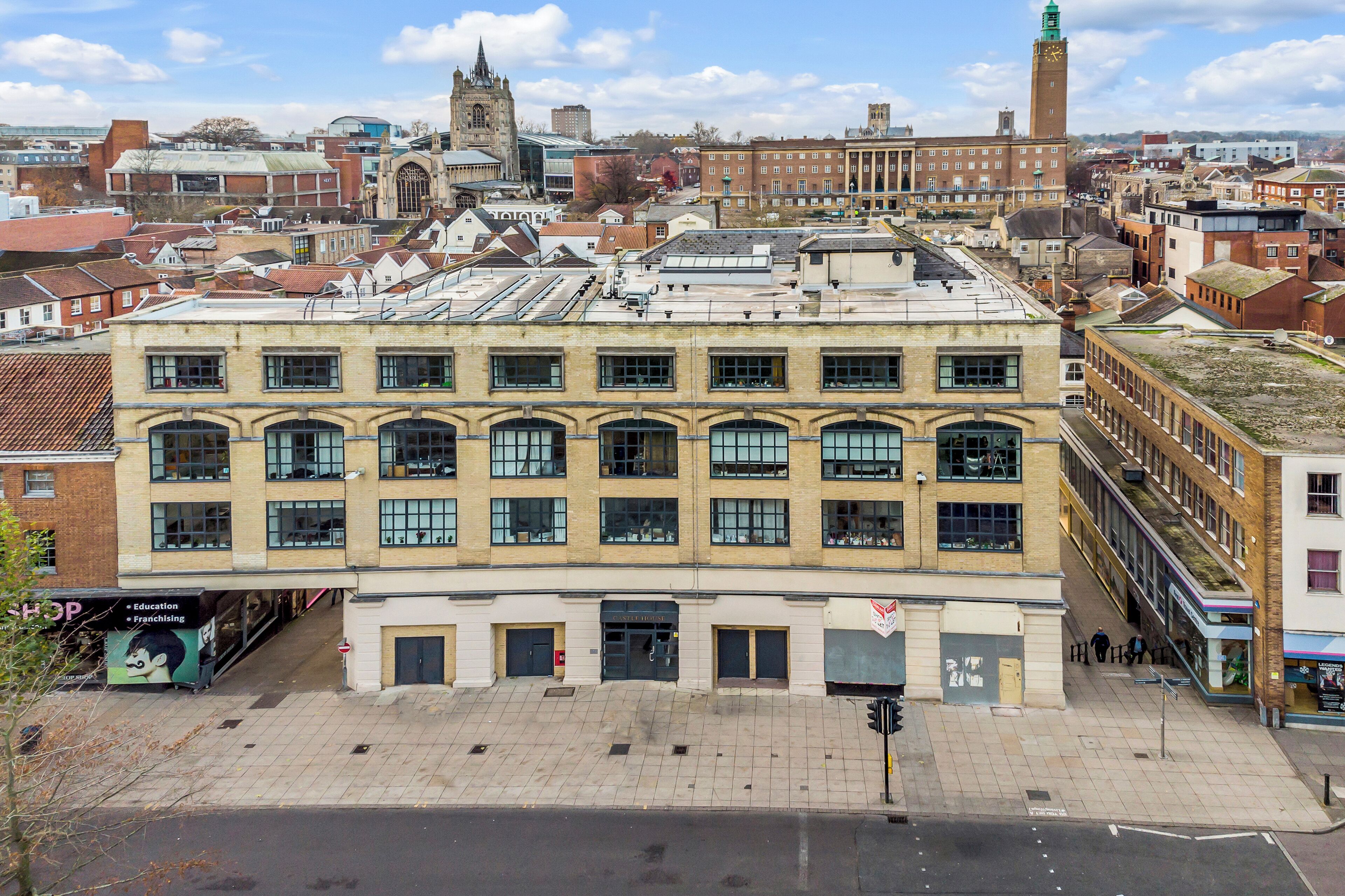A multi-story building with a flat roof, large windows, and a ground-level entrance.