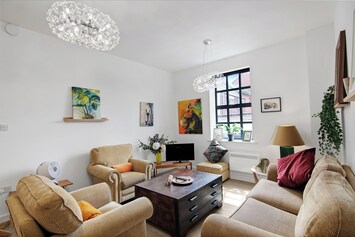 An image of the living room showing the beautiful natural light from the windows and prints from the artist