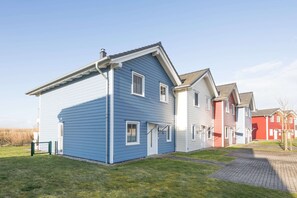 A row of modern houses with a paved walkway in between.