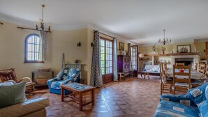 Ein geräumiges Wohnzimmer mit großem Fenster, Kamin und Essbereich.