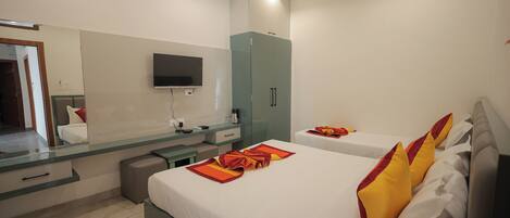 A hotel room with a bed, a TV, a mirror, a wardrobe, and a desk.