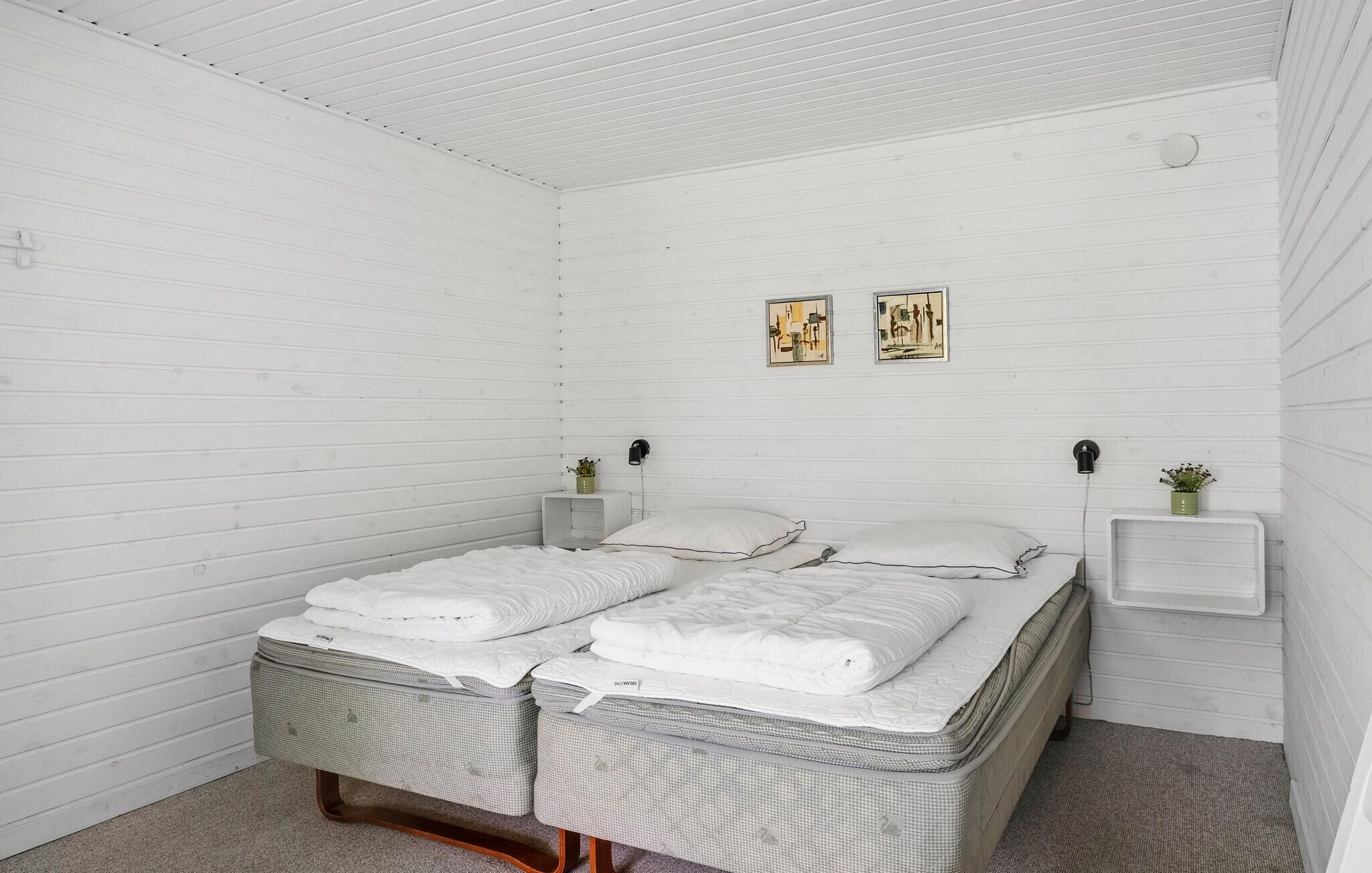 Ein Schlafzimmer mit einem Bett, zwei Nachttischen und zwei Wandleuchten.