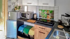 A compact kitchen with a microwave, kettle, and a coffee maker. There are storage bins and a sink. - Gorgeous home in Ilawa with WiFi (Ilawa)