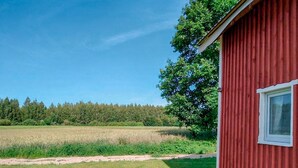 A red building with a window, surrounded by a grassy field and a forest. - Gorgeous home in Ilawa with WiFi (Ilawa)
