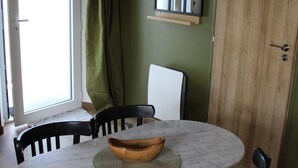 A dining area with a round table, black chairs, and a woven placemat.