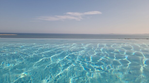 Vista clara de uma piscina com a costa ao longe.