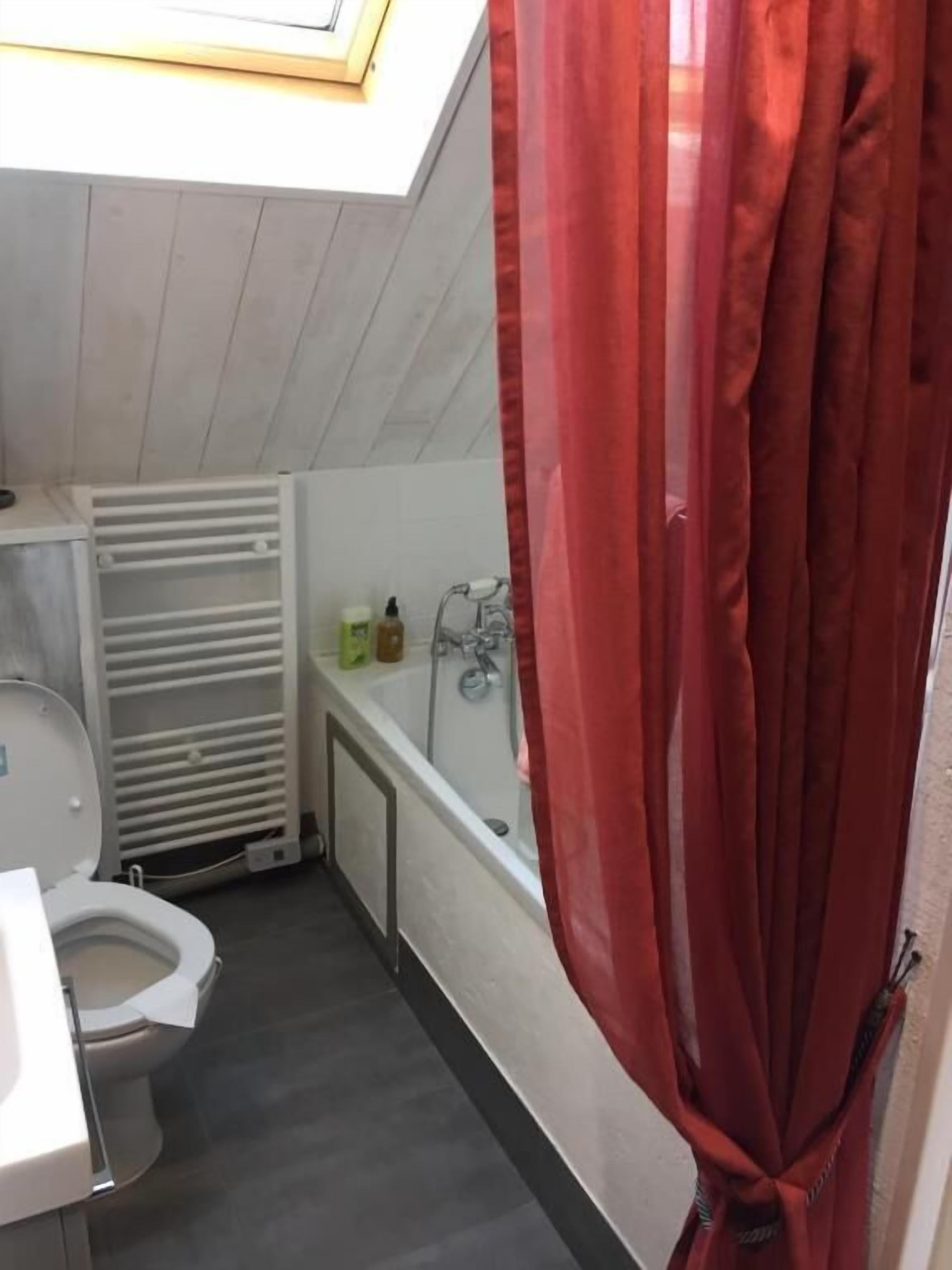 Een compacte badkamer met toilet, wastafel en douche.