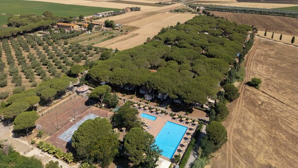 An aerial view of a property with a swimming pool, surrounded by fields and trees, with a road running alongside. - Beautiful apartment in villa for 5 guests with pool, A/C, WIFI, terrace and pets allowed (Capalbio)