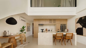 Une cuisine moderne dotée d’un îlot central, de meubles en bois et d’un coin repas avec une table et des chaises.