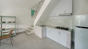 Una cocina moderna con armarios blancos, una estufa a gas y un horno empotrado.