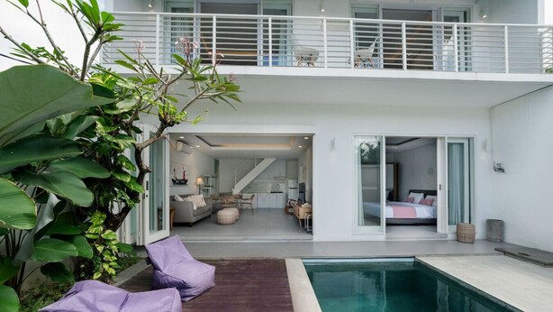 Una casa moderna con piscina, balcón y zona de comedor.