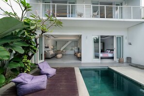 Una casa moderna con piscina, balcón y zona de comedor.