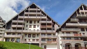 A multi-story hotel with balconies, a stone facade, and a sign indicating 'Accueil'. - Spacious apartment in Super-Besse with terrace and garage (Besse-et-Saint-Anastaise-Super Besse)