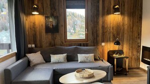 Una habitación acogedora con un sofá modular, una mesita redonda, una lámpara y una chimenea.