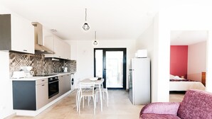 A modern apartment with a kitchen, dining area, and a living room with a sofa. - Barn La Roca Masia - Les Pivoines, swimming pool, garden, 1 bedroom 2/4 persons (Assier)