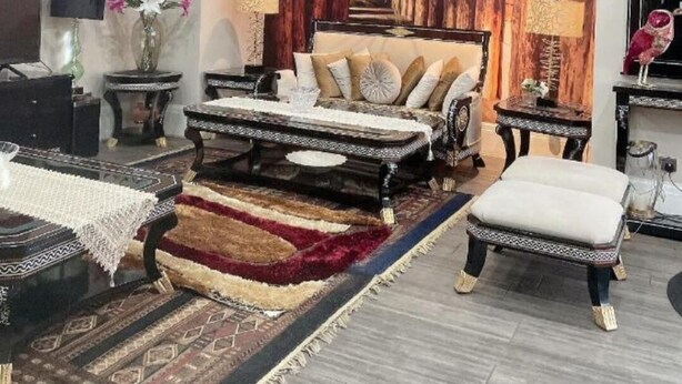 Un dormitorio moderno con una cama grande, una zona de estar y un tocador con espejo.