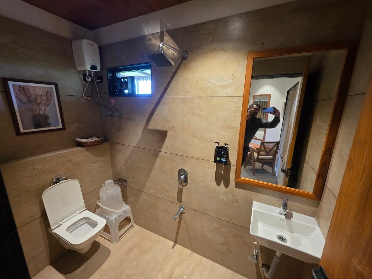 A bathroom with a toilet, bidet, shower, sink, and a mirror.