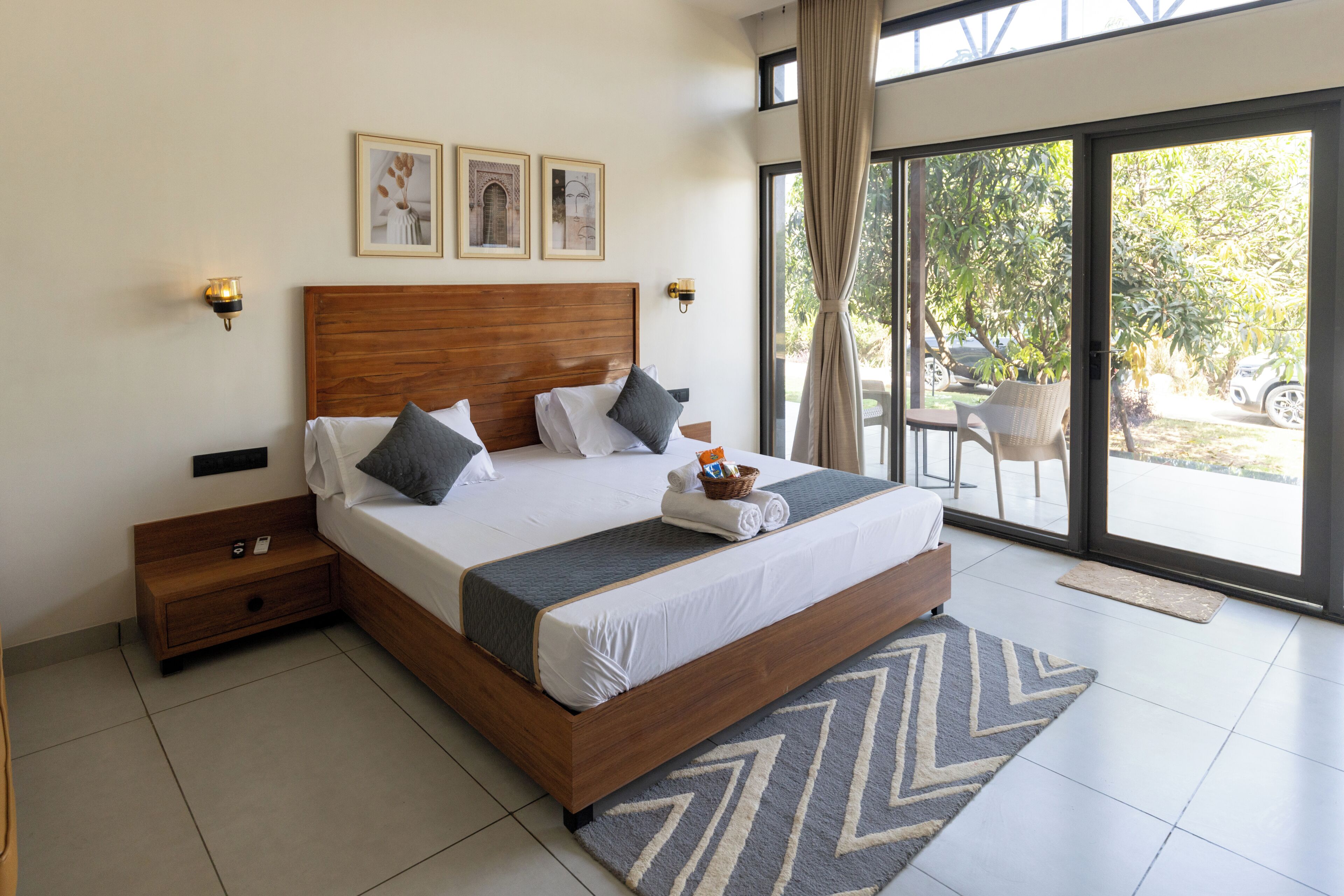 Un dormitorio moderno con una cama grande, cabecera de madera y vistas al exterior a través de un ventanal corredera.