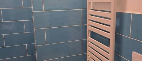 A bathroom with blue tiled walls, a white sink, and a towel rack.