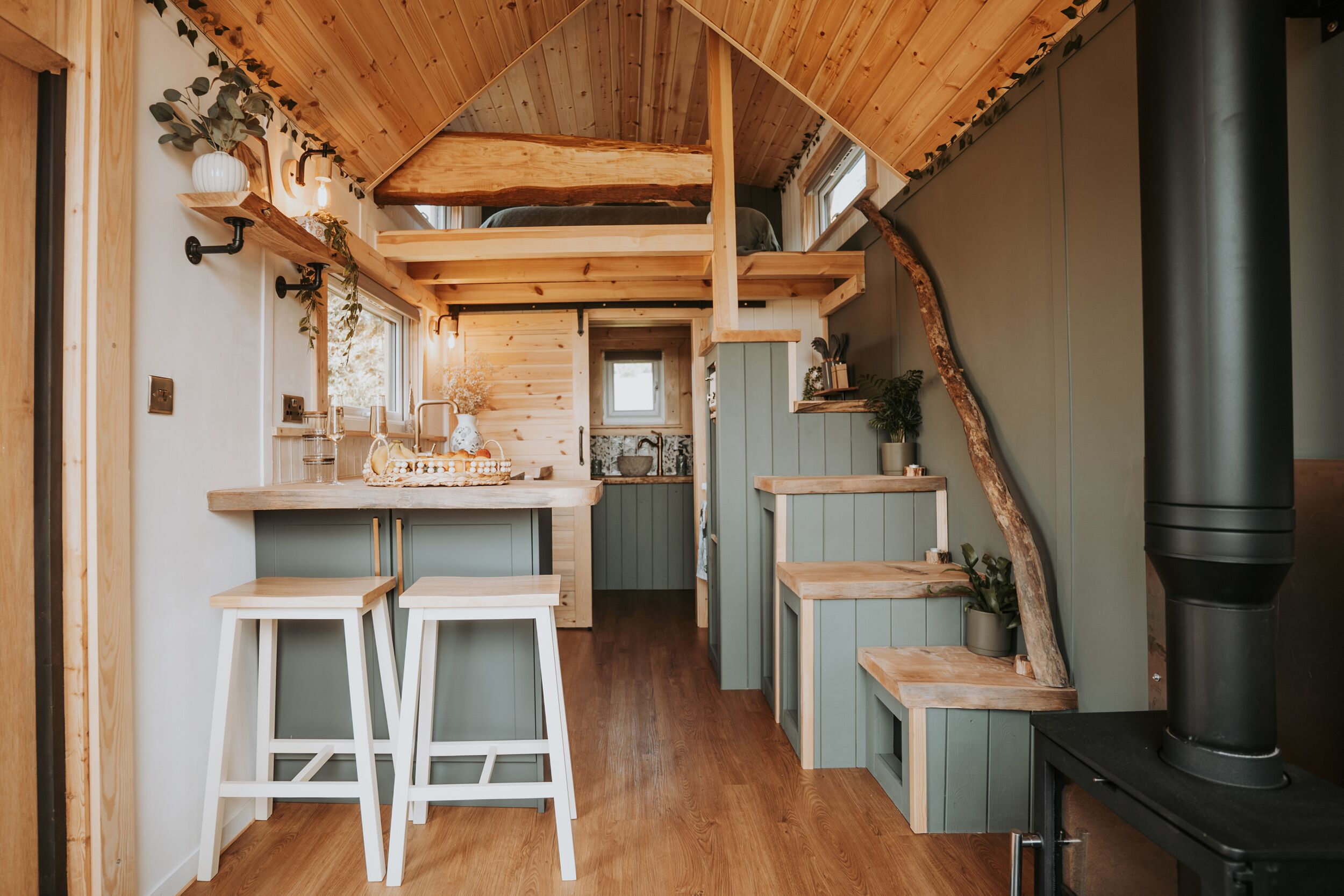 A cozy kitchen with wooden beams, a central island, and a black stove.