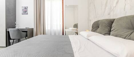 Une chambre d’hôtel moderne, dotée d’un grand lit, d’un bureau et d’une chaise.