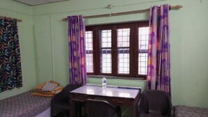 A room with a bed, a desk, and two chairs.