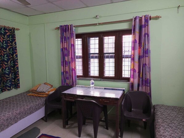 Una habitación con cama, escritorio y dos sillas.