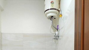 Une petite salle de bain comprenant des toilettes, une douche et un porte-rouleau de papier toilette.
