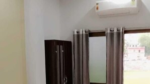 Une chambre à coucher avec un lit, une armoire et une fenêtre avec des rideaux.