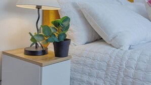 A neatly made bed with white bedding and a yellow headboard.